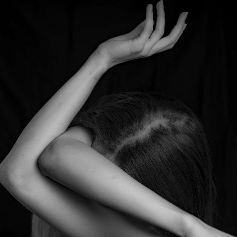 girl with arms crossed over face